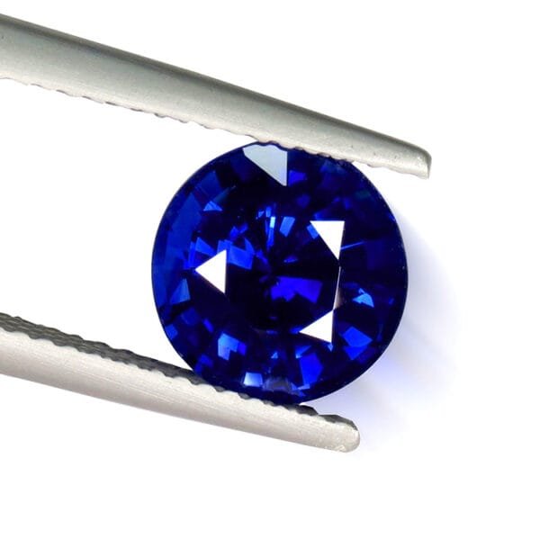 Sri Lankan blue sapphire 3.18 ct round brilliant – held by tweezers