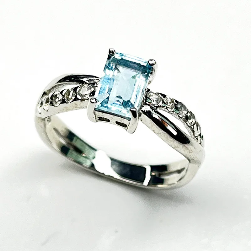Silver aquamarine ring with rectangular cut gemstone and sparkling zircon details