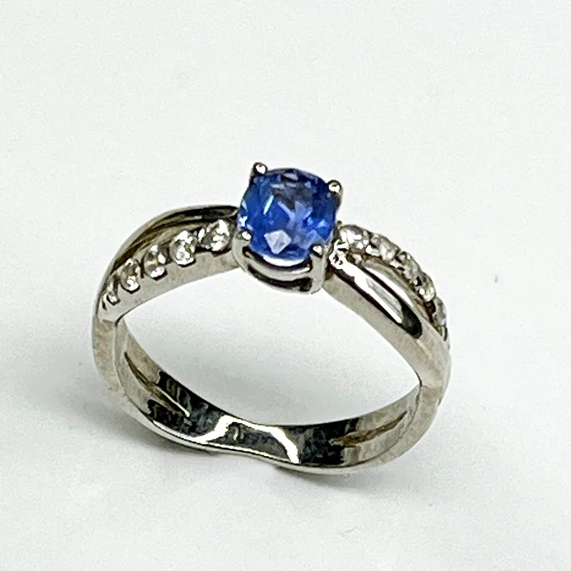 Elegant 925 silver ring featuring an oval-cut sapphire gemstone with sparkling zircon side stones