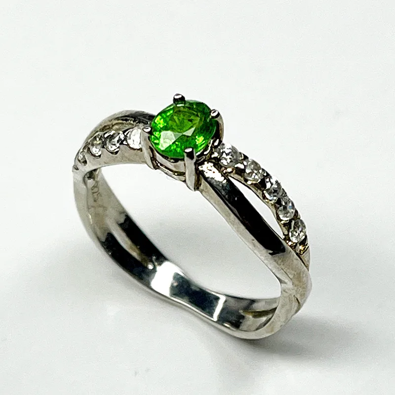 Silver ring featuring a vivid tsavorite garnet and white zircon accents