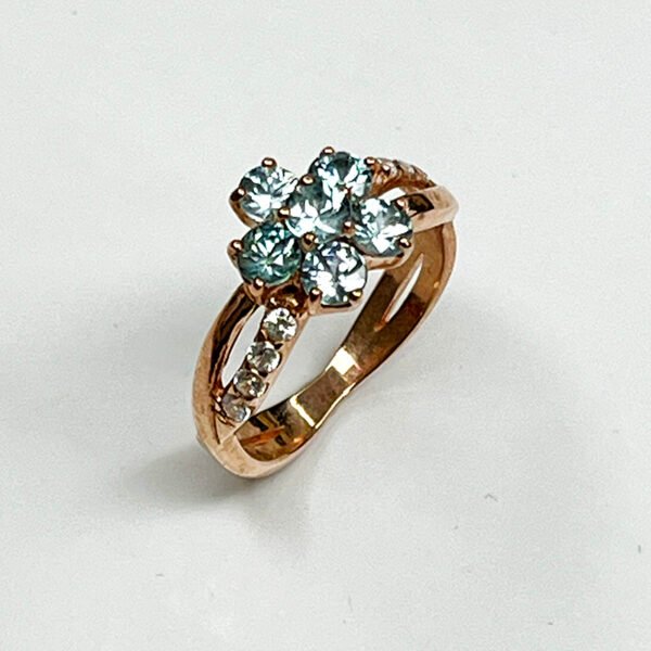 Vue de côté bague fleur zircon bleu argent or rose