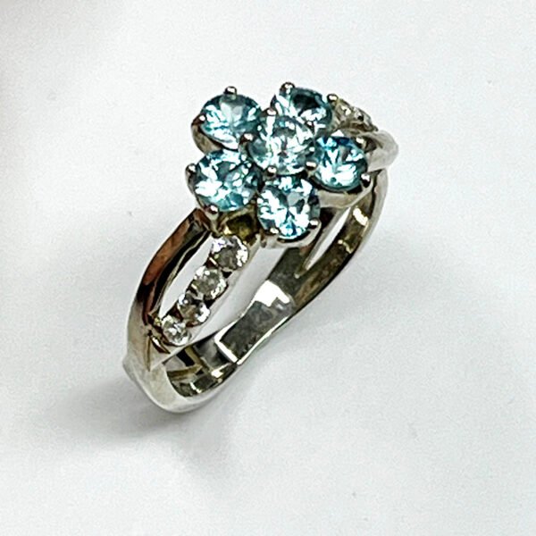 Vue de côté bague fleur zircon bleu argent or blanc