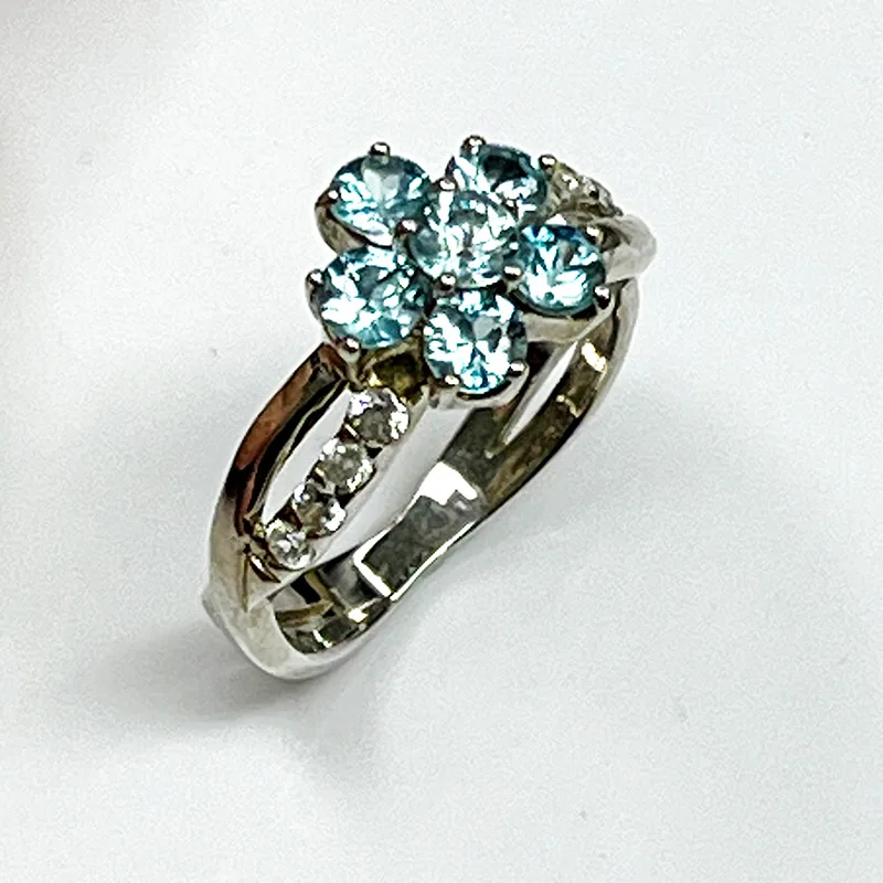 Vue de côté bague fleur zircon bleu argent or blanc