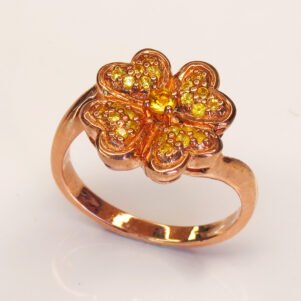 Vue de face d’une bague florale en saphirs jaunes et argent rose